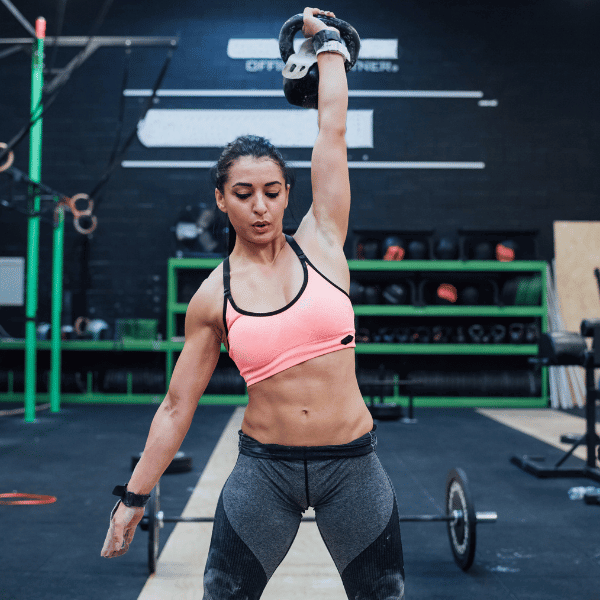 CrossFit athlete performs a KB press to fix her shoulder pain when pressing